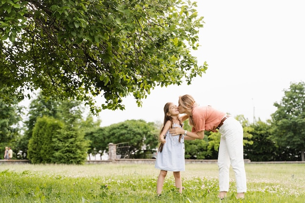Mutter küsst und umarmt ihre Tochter Hapiness Emotion Familienwerte Glücklicher Familienlebensstil Glück und Freude der Mutter, die ihr Kind umarmt