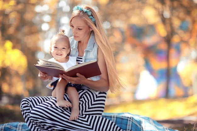 Mutter liest ein Buch, kleine Tochter im Park