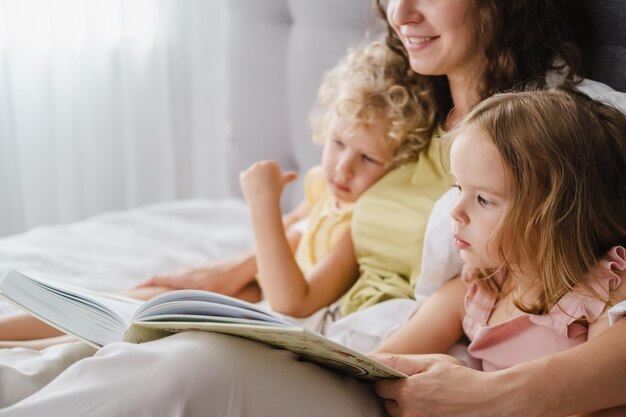 Foto mutter liest ihren töchtern zu hause ein buch vor