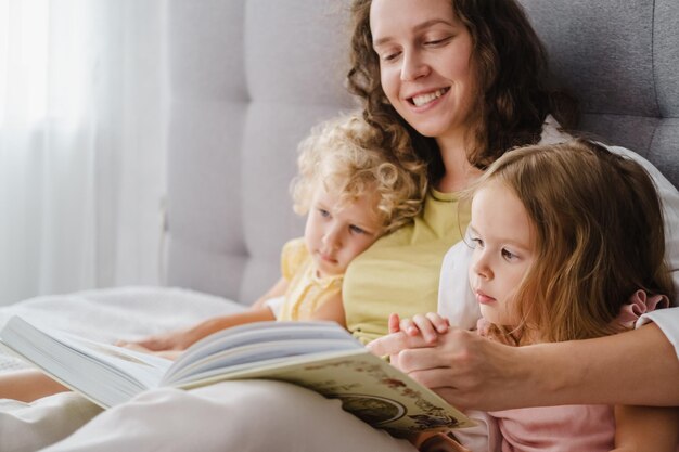 Foto mutter liest ihren töchtern zu hause ein buch vor