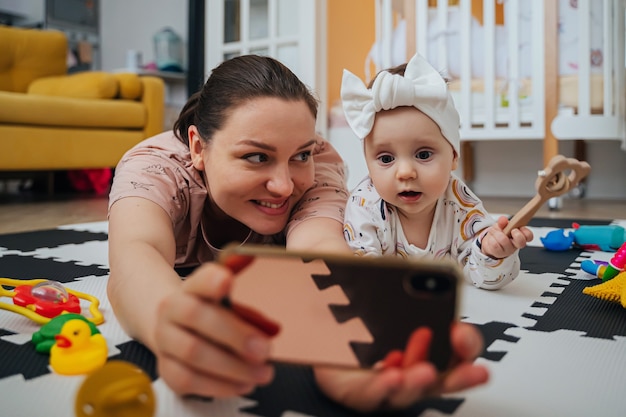 Mutter mit Baby, die Cartoon auf dem Smartphone aufpasst