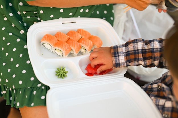 Mutter mit baby essen sushi auf der straße auf der straße