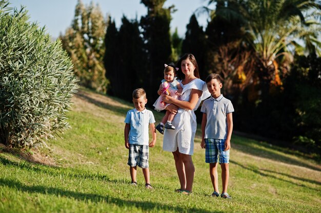 Foto mutter mit drei kindern im türkei-resort gegen palmen.