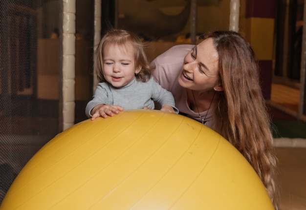 Mutter mit einem kleinen Mädchen spielt im Kinderunterhaltungszentrum. Familienurlaub