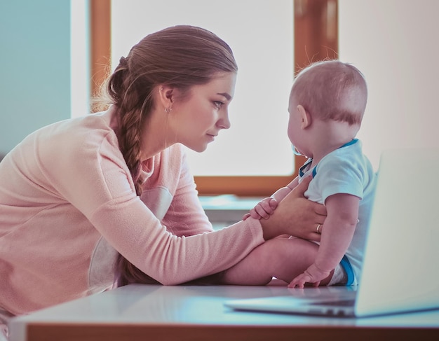 Mutter mit ihrem Baby in der hellen Küche zu Hause