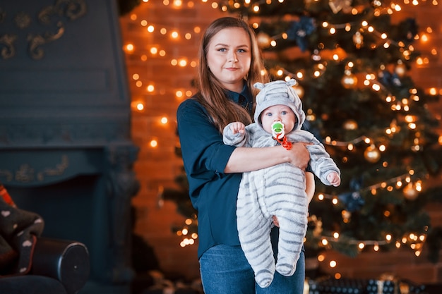 Mutter mit ihrem Kind zusammen im weihnachtlich dekorierten Raum.