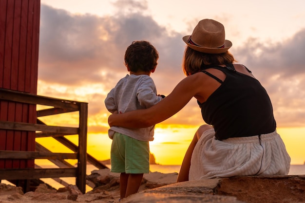 Mutter mit ihrem Sohn bei Sonnenuntergang am Strand von Cala Comte auf der Insel Ibiza Balearen