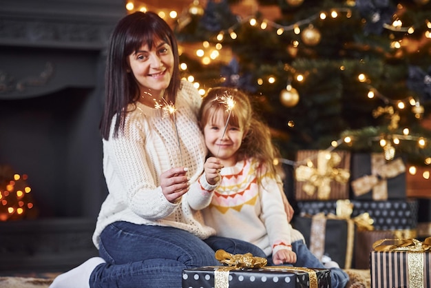 Mutter mit ihrer kleinen Tochter feiert Weihnachten mit Geschenken.