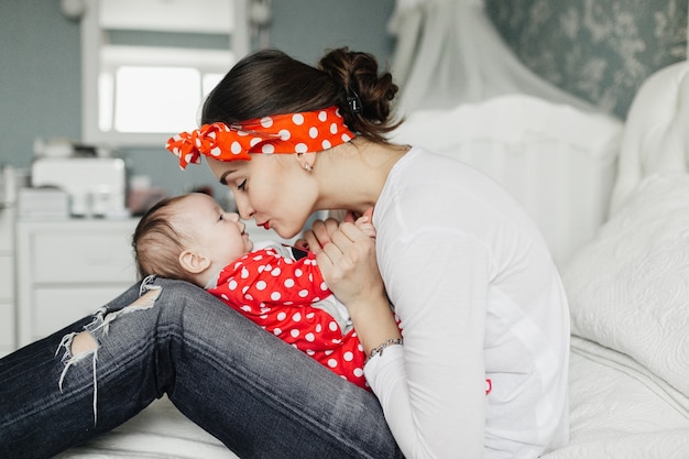 Foto mutter mit ihrer kleinen tochter spielen im schlafzimmer