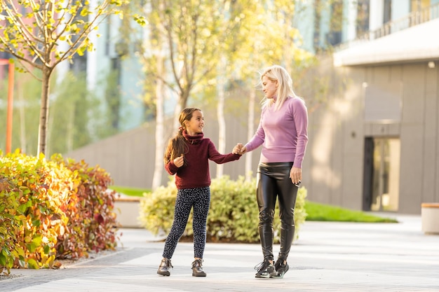 Mutter mit ihrer Tochter in herbstlicher Gasse.