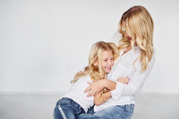 Mutter mit ihrer Tochter zusammen im Studio mit weißem Hintergrund.