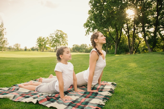 Mutter mit Kind macht Yoga-Übung