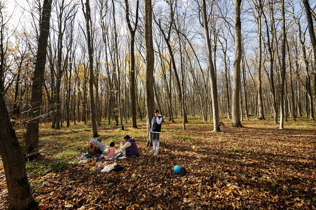 Mutter mit Kindern beim Familienpicknick im Herbstwald