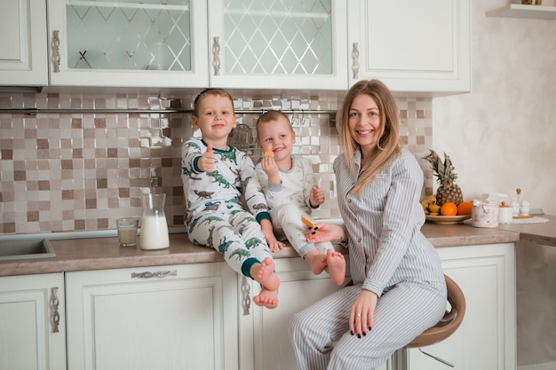 Mutter mit Kindern beim Frühstück in der Küche