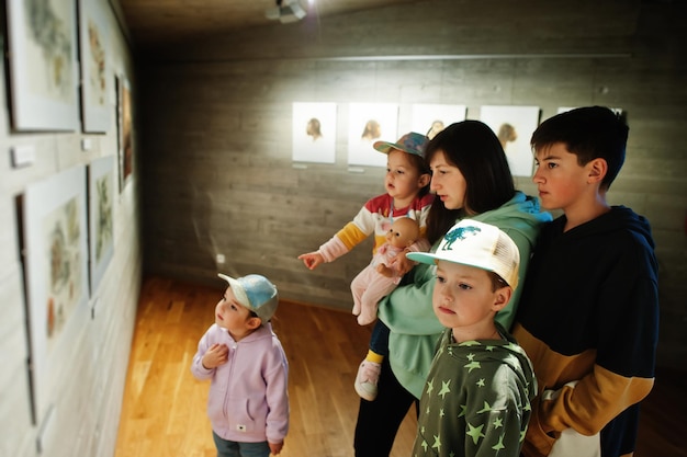 Mutter mit Kindern, die Ausstellungen in Museumshallen erkunden