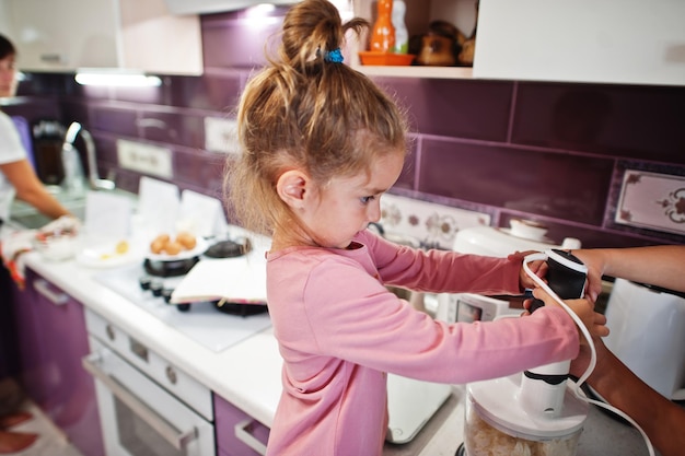 Mutter mit Kindern, die in der Küche glückliche Kindermomente kochen