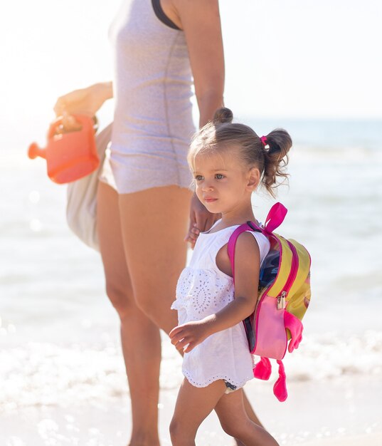 Mutter mit kleiner Tochter am Strand spazieren gehen