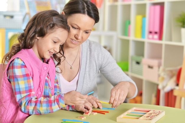 Mutter mit kleiner Tochter, die mit Stöcken zählt