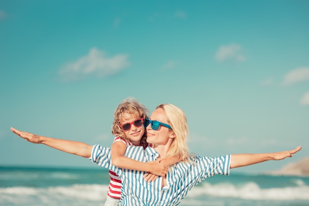 Foto mutter mit offenen armen und tochter umarmt sie am strand