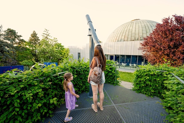 Mutter mit Tochter am Observatorium im Teleskop im Freien