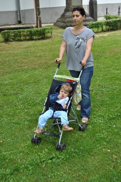 Mutter mit Tochter im Kinderwagen im Park spazieren gehen