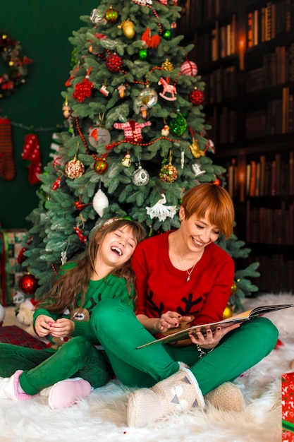 Mutter mit Tochter nahe Weihnachtsbaum