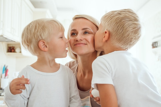 Mutter mit zwei Söhnen, die Feiertagstorte in der Küche kochen. Lässiges Leben