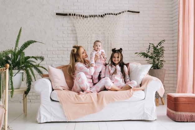 Mutter mit zwei Töchtern im gleichen rosa Pyjama