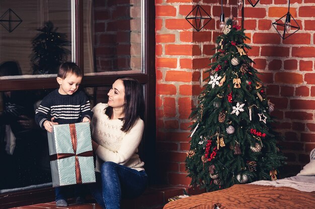 Mutter schenkt ihrem Sohn Weihnachten.