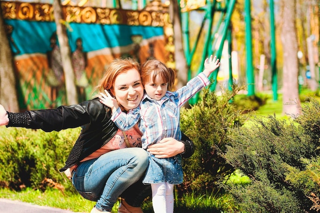 Mutter, Sohn spielen auf dem Spielplatz und lachen beim Sommerspaziergang. sonniger Tag. Familienurlaub. Kinder