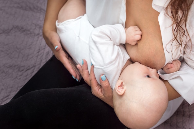 Mutter stillt ihr Baby auf dem Bett