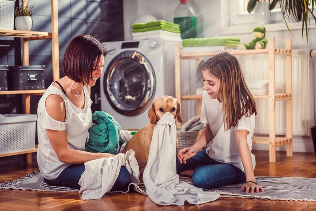 Mutter, Tochter und Hund, die Spaß an der Waschküche haben