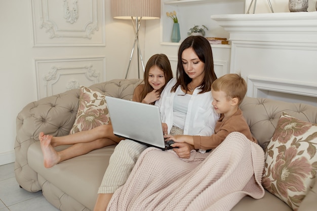 Mutter Tochter und Sohn spielen auf dem Laptop. Familienerholung und Freizeit