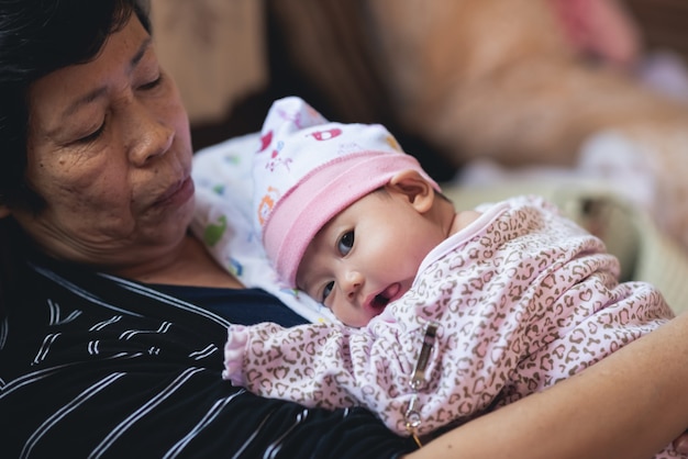 Mutter umarmt ihr Baby, das auf dem Sofa ruht