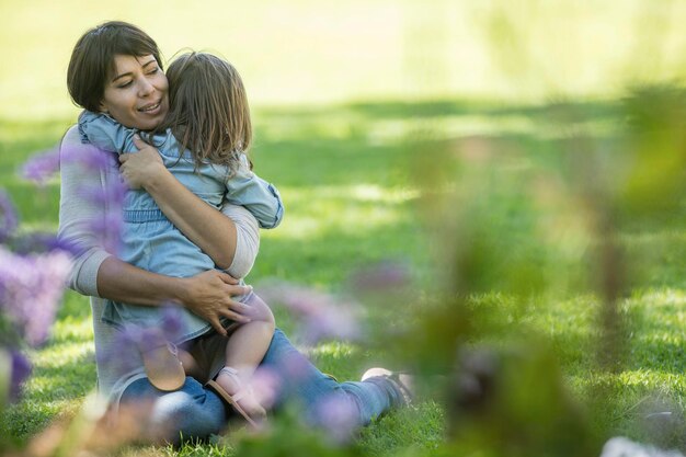 Mutter umarmt Tochter im Garten