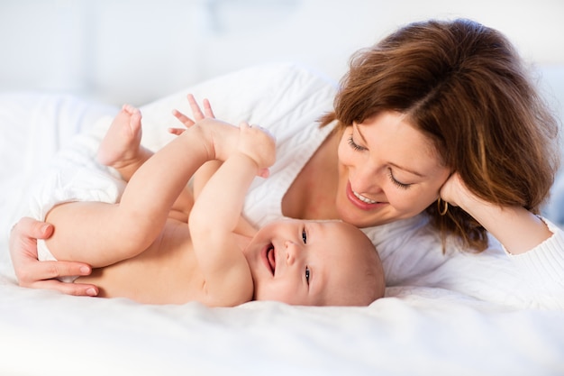 Mutter und Baby auf einem weißen Bett