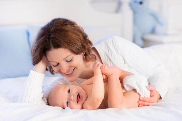 Mutter und Baby auf einem weißen Bett