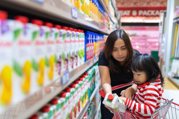 Mutter und Baby beim Einkaufen im Supermarkt Thailändische Frau hat eine Tochter