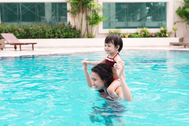 Mutter und Baby, die Spaß im Pool haben. Sommerferien und Urlaubskonzept