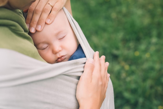 Mutter und Baby in der Natur im Freien Baby in Wickelträger Frau mit kleinem Kind im Babytragetuch