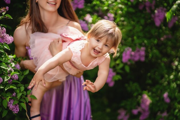 Mutter und Baby spielen im Park. geblühte Bäume