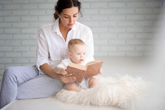 Mutter und Baby spielen und umarmen. Glückliche Familie