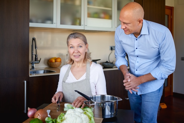 Mutter und erwachsener Sohn in der Küche bereiten Essen zu