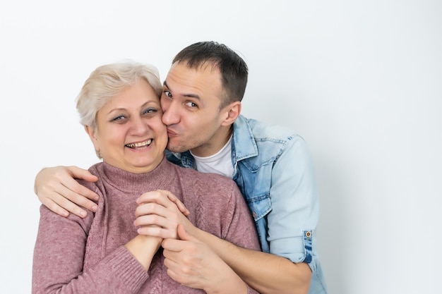 Mutter und erwachsener Sohn zusammen, Sohn gibt Mutter einen Kuss.