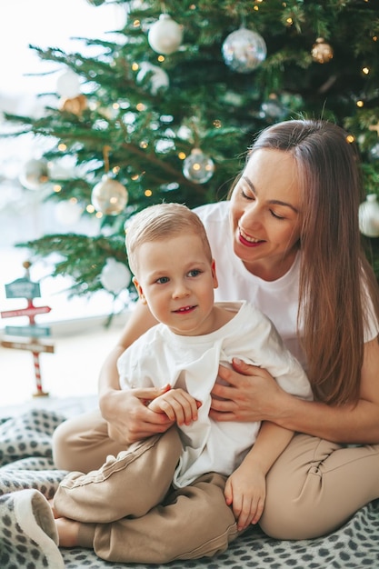 Mutter und ihr kleiner Sohn nahe dem Weihnachtsbaum