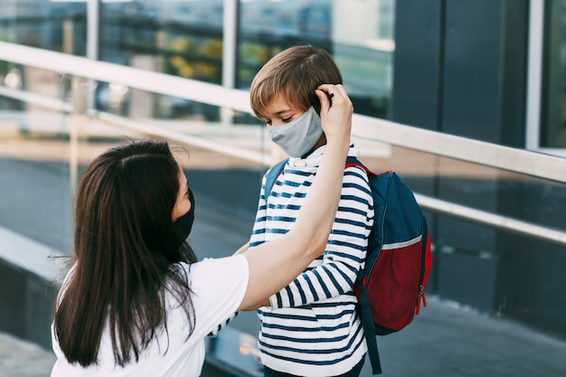 Mutter und ihr Sohn tragen Schutzmasken im Freien