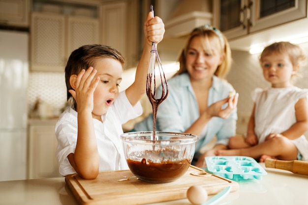 Mutter und ihre Kinder schmecken geschmolzene Schokolade