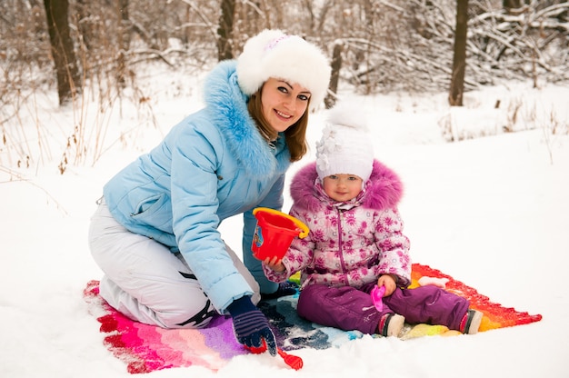 Mutter und ihre kleine Tochter genießen schönen Wintertag im Freien.