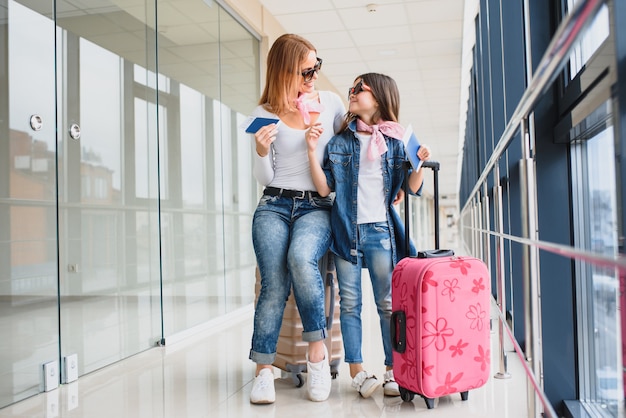 Mutter und ihre kleine Tochter mit Gepäck am Flughafen