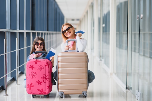 Mutter und ihre kleine Tochter mit Gepäck am Flughafen